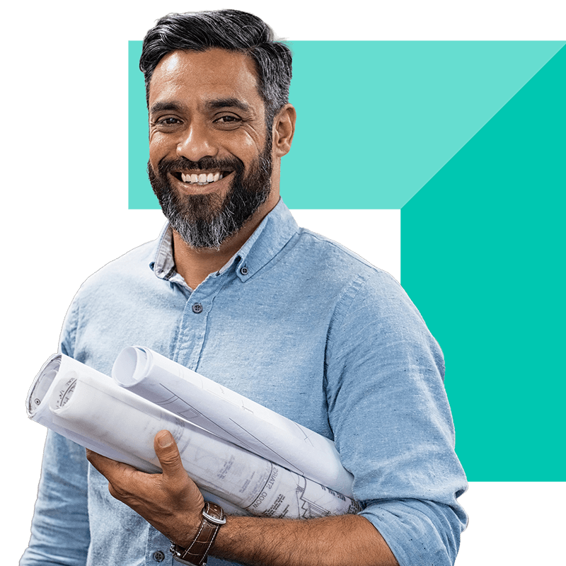 A professional holding building plans and smiling