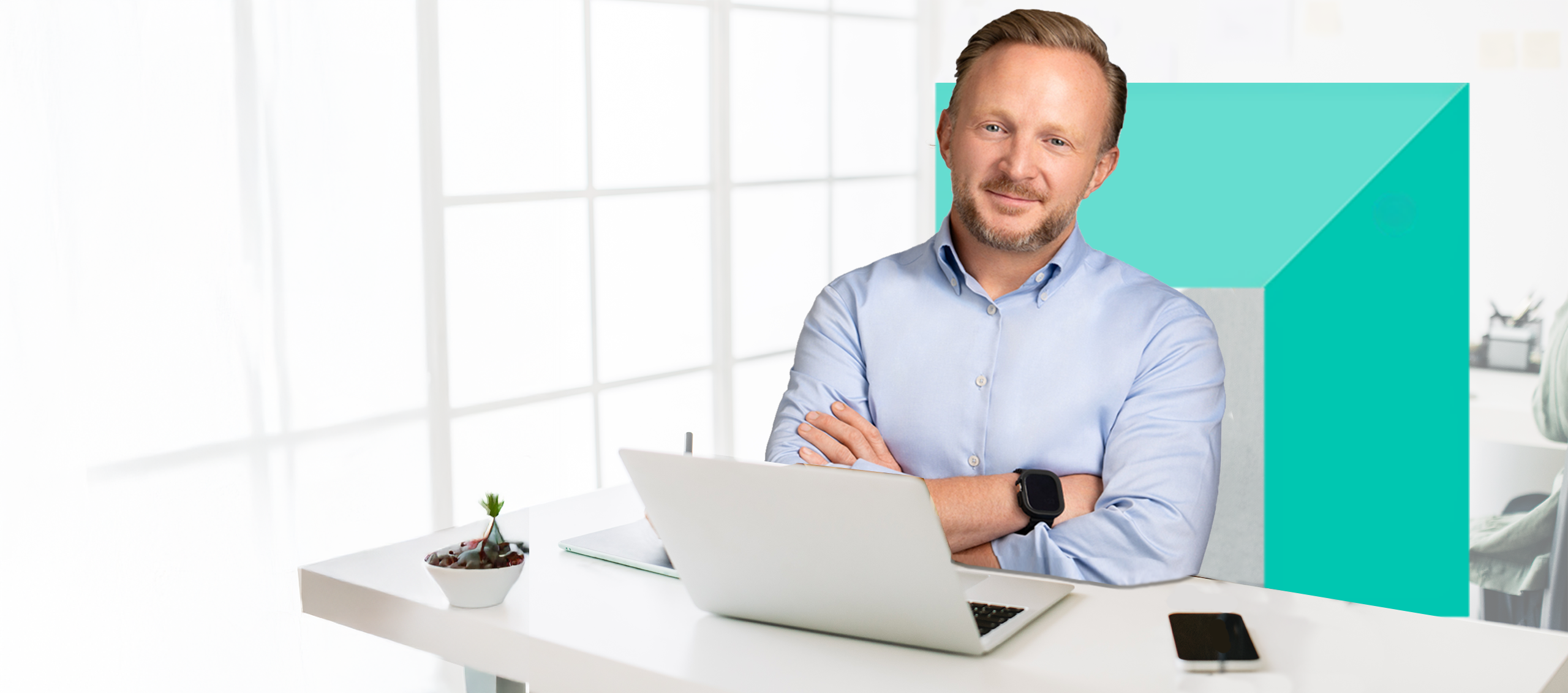 Banker sitting at desk with arms folded. 