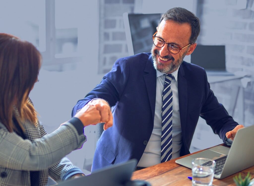 MIddle-aged businessman fist-bumping colleague