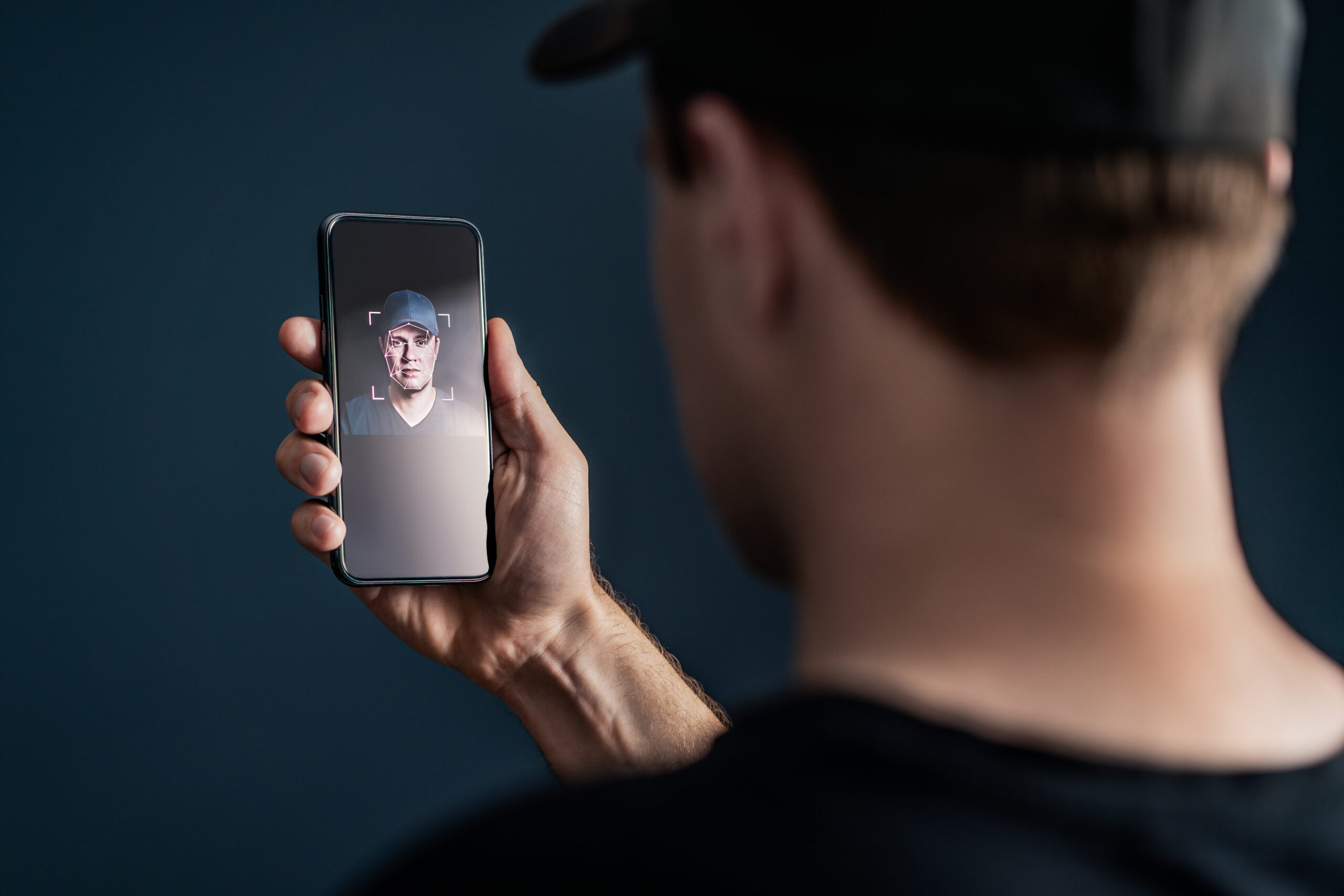 Face recognition with facial scan in phone. Identification and verification to unlock smartphone. Deep fake technology. Man using cellphone. AI mobile tech and biometric id authentication. stock photo