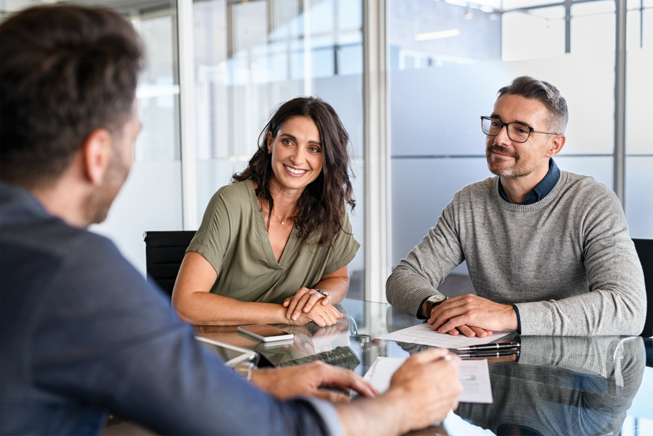 Two happy people working with a banker.
