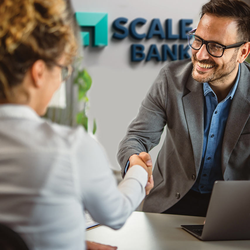 Man shaking hands with a Scale Bank loan specialist